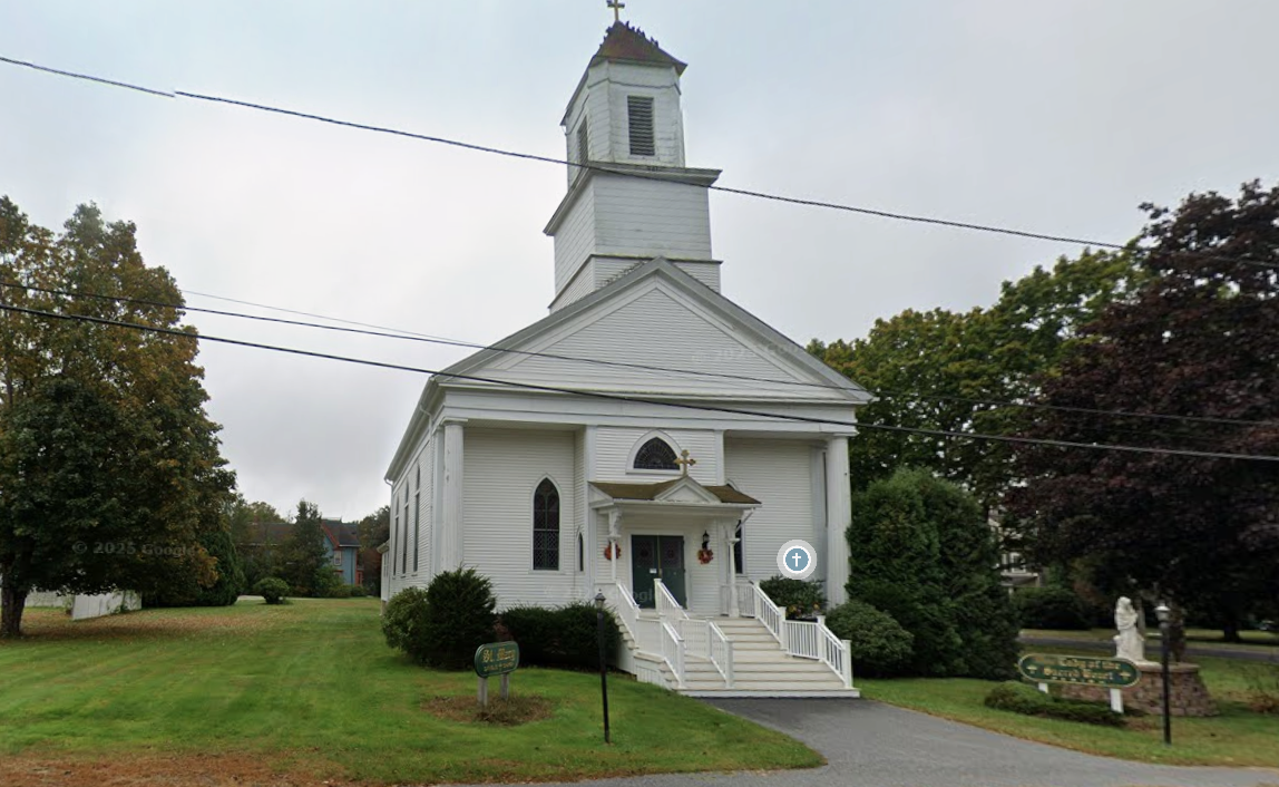 The white clapboard exterior of Emmanuel Orthodox Church with its steeple and cross