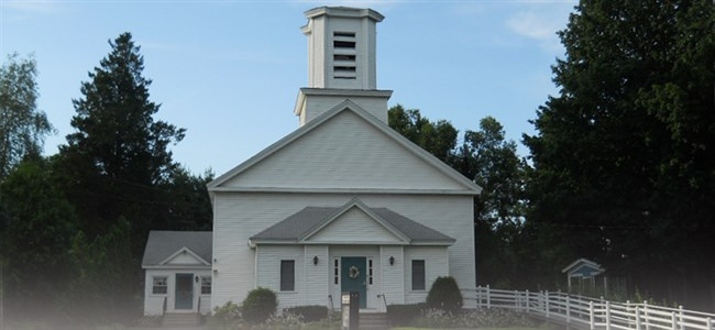 The white clapboard George Whitfield Methodist Church in downtown West Brookfield, with its square bell tower and columned entrance, where Emmanuel worshiped at a Saturday evening Mass.
